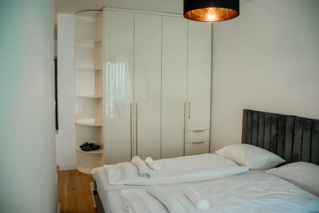 Schlafzimmer mit einem Bett mit weißer Bettwäsche in der Unterkunft My River Walk apartment - Ilidza in Sarajevo