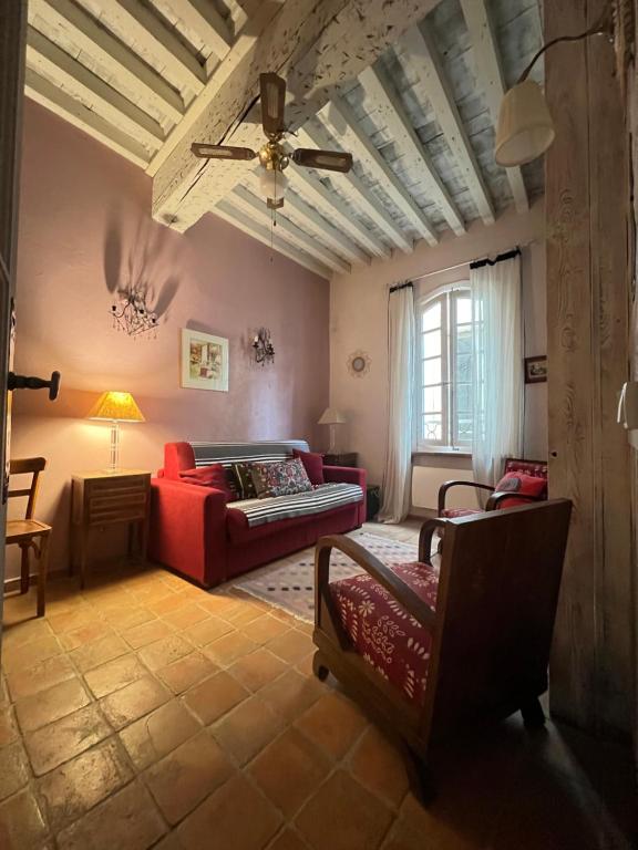 a living room with a red couch and a ceiling at à St Rémy Petite maison au coeur du village in Saint-Rémy-de-Provence
