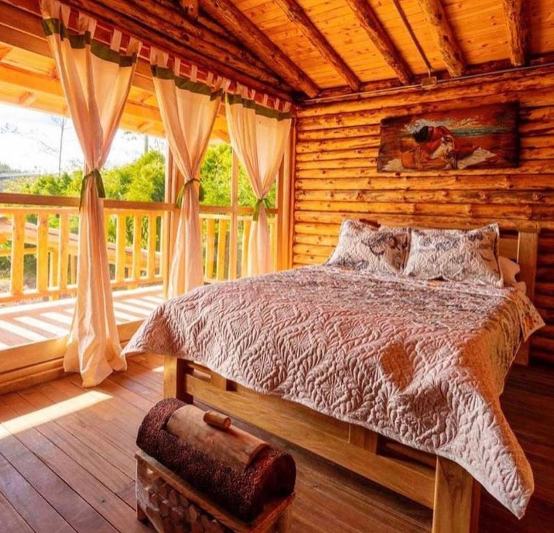 a bedroom with a bed in a log cabin at NIGUITO HOTEL in Santa Elena