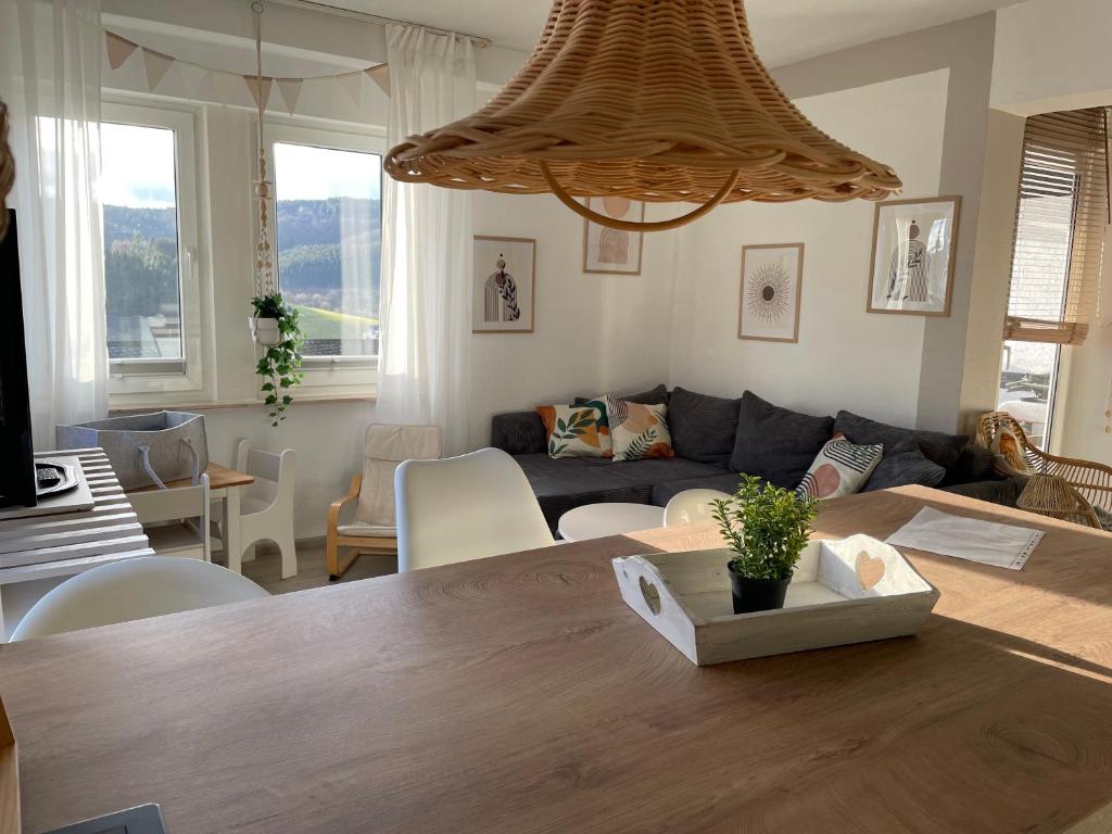 a living room with a table and a couch at Ferienwohnung Dorfblick mit 2 SZ, Balkon und Ski- oder eBike Keller in Winterberg