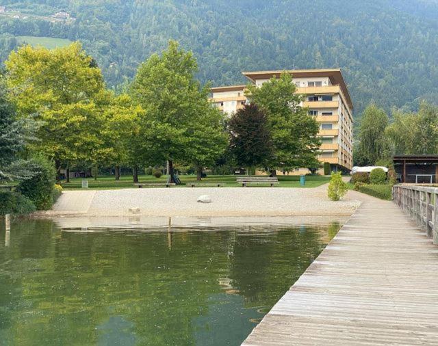 un edificio junto a una masa de agua junto a un edificio en Seeappartement LUNA am Ossiachersee, en Bodensdorf