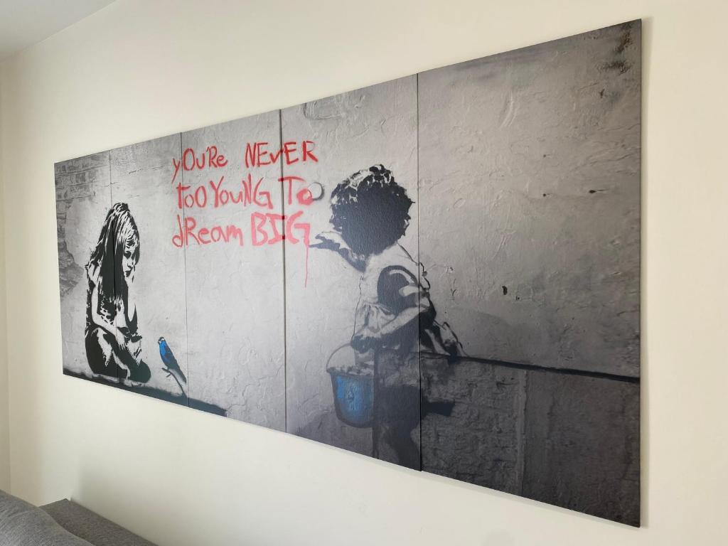 a wall with a painting of a child standing in a bathroom at Espacioso Apartamento Familiar en Aranjuez - Confort, Tranquilidad y Netflix Incluido in Aranjuez