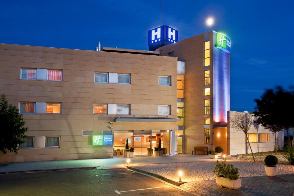 a hospital building with a lit up tower at night at Hotel Holiday Inn Express Madrid-Rivas, an IHG Hotel in Rivas-Vaciamadrid