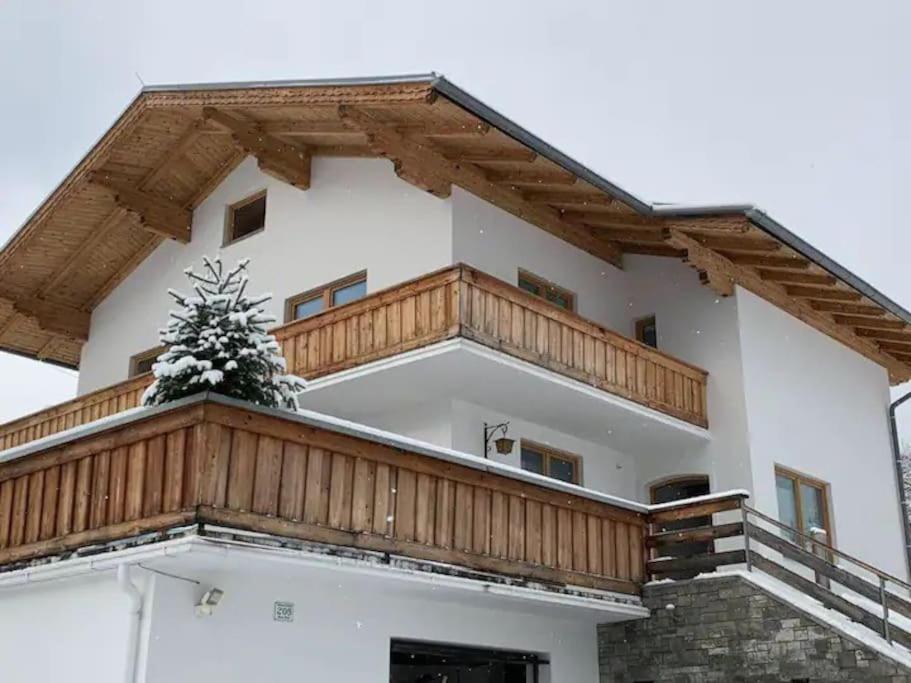 a house with a balcony with a christmas tree on it at Chalet zum Wohlfühlen in Ramsau am Dachstein
