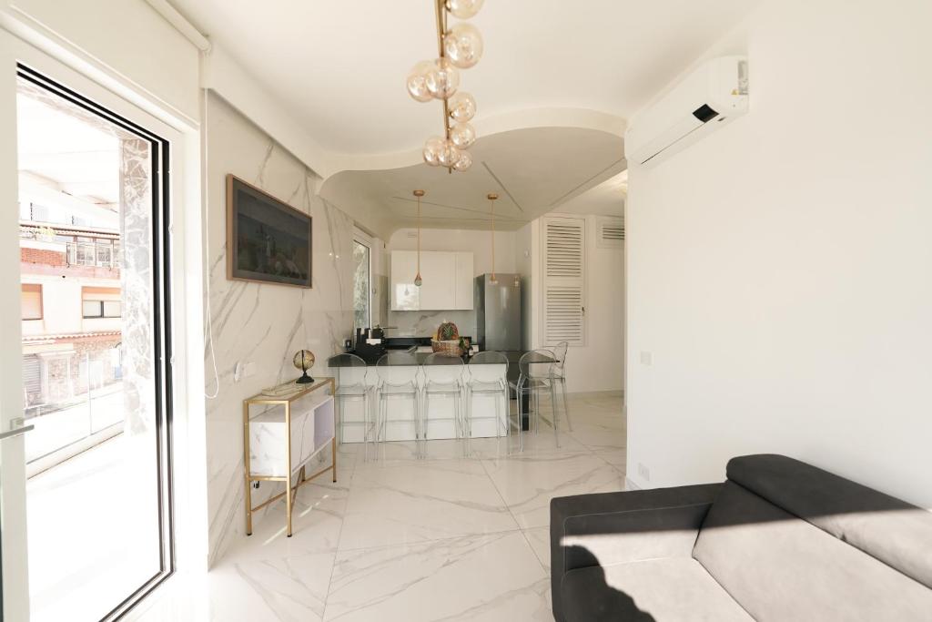 a living room with a couch and a kitchen at Mazzarò Luxury Apartment Taormina in Taormina