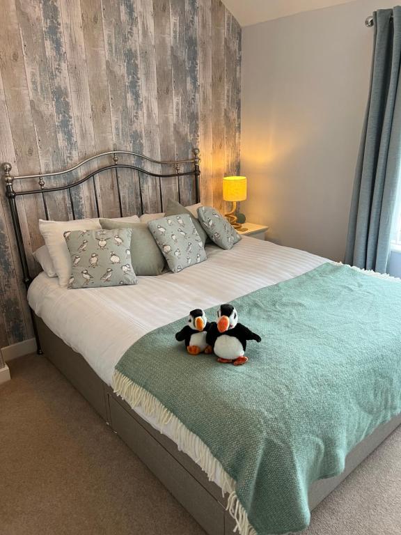 two stuffed animals are sitting on a bed at 5 Beechcroft Cottage - Seahouses Northumberland in Seahouses