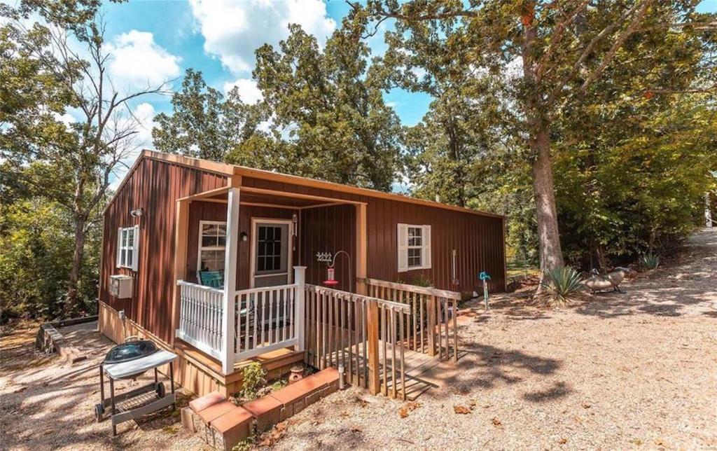 een tiny house met een veranda en een grill bij Dragonfly Meadows Guesthouse in Rangely