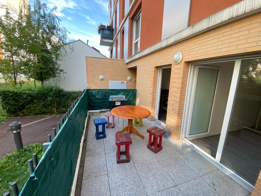 a patio with a table and chairs on a balcony at appartement proche de paris in Saint-Denis