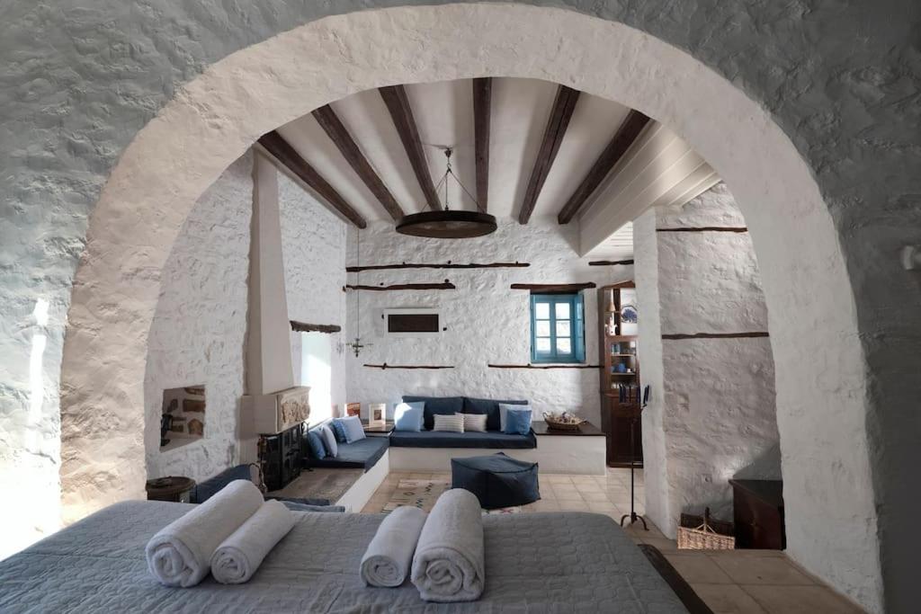 a living room with a large stone wall at Historical Stone Manor-Upper floor in Hydra
