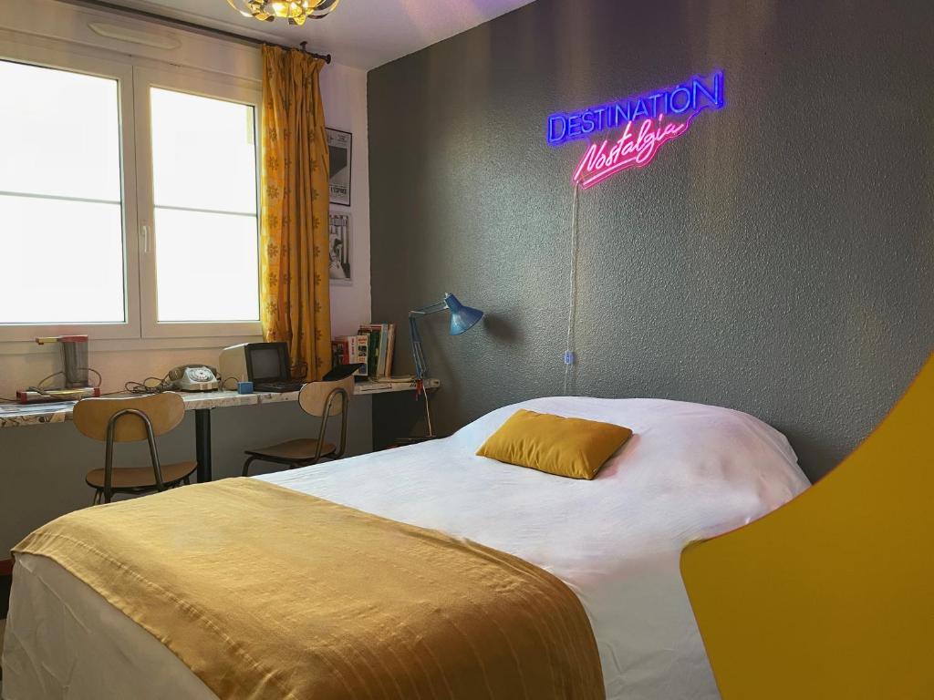 Dormitorio con cama con letrero de neón en la pared en Ambiance 80 Stranger Things, en Lunéville