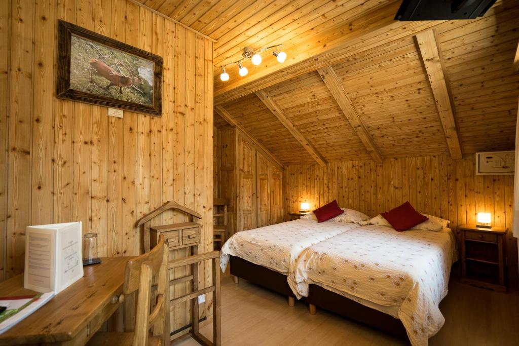 ein Schlafzimmer mit einem Bett in einer Holzhütte in der Unterkunft Hotel de Moiry Supérieur in Grimentz