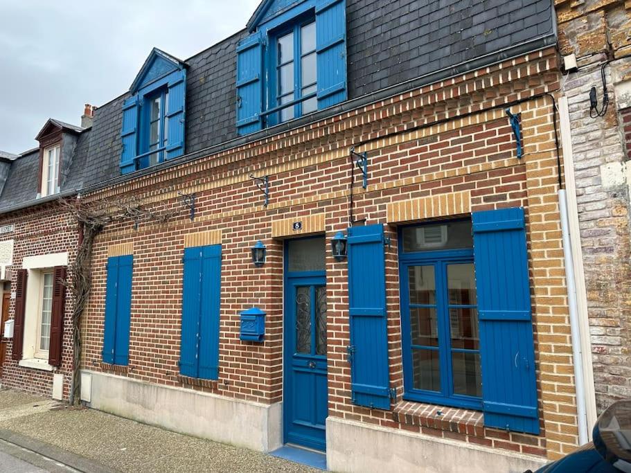 ein Backsteingebäude mit blauen Türen und Fenstern in der Unterkunft Gîte du Moulin - Appartement plein centre ville - spacieux 2p - 1er etage maison de pécheur à 100m de la plage in Le Crotoy