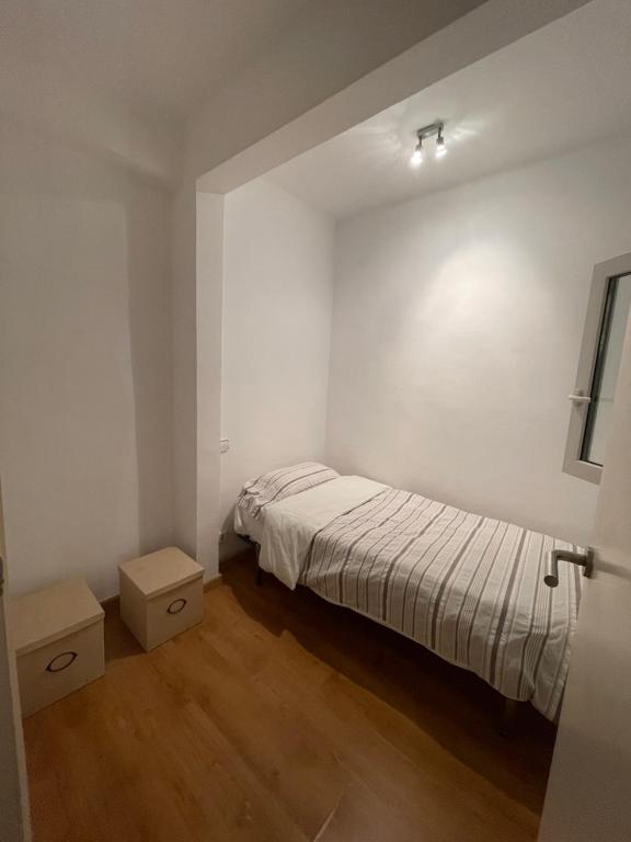 巴塞隆納的住宿－toko，一间白色的小卧室,配有床和2盒