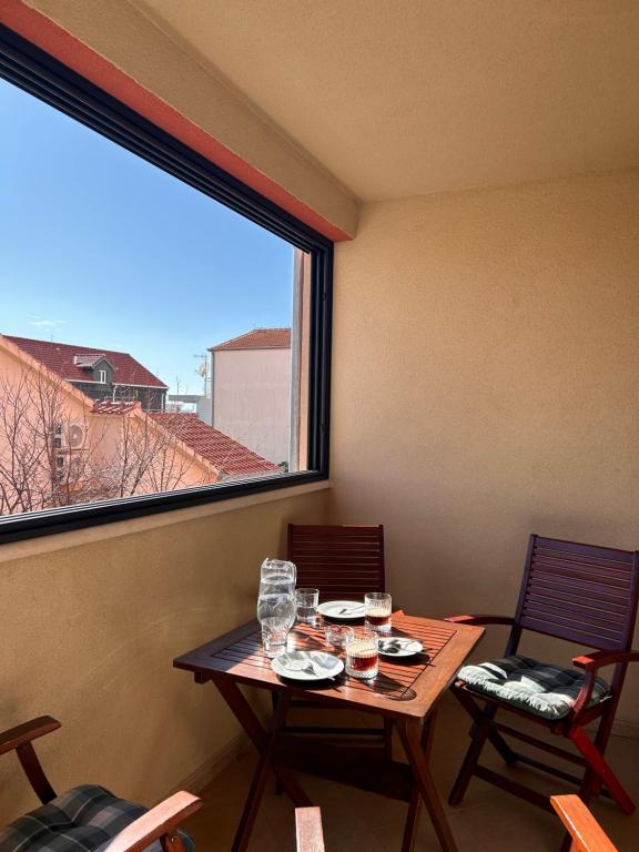 mesa y sillas en una habitación con ventana en Apartment Agata, en Trogir