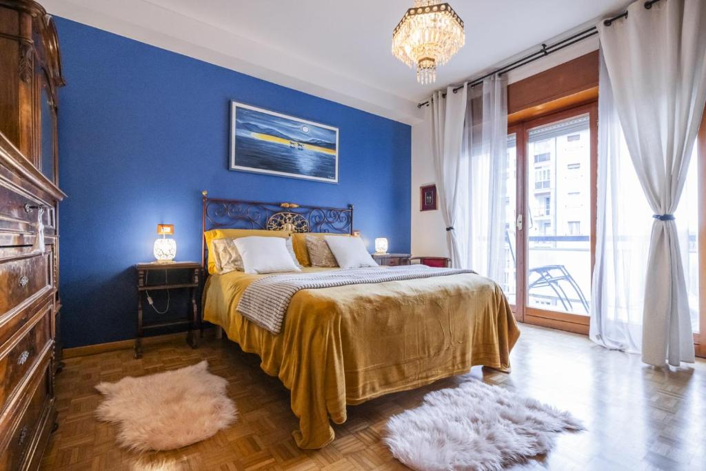 a blue bedroom with a bed and a blue wall at Big Deluxe apts Italian Style Lake&Terrace in Lecco