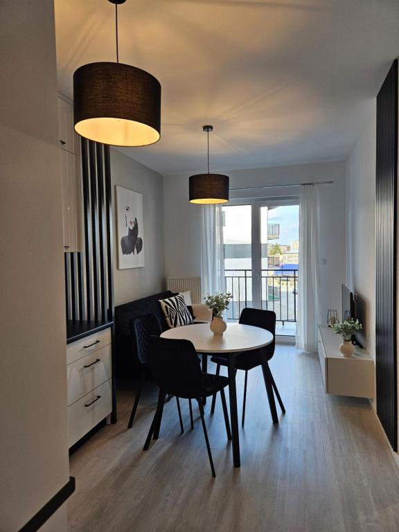 cocina y sala de estar con mesa y sillas en Apartament - Osiedle Przylesie en Namysłów