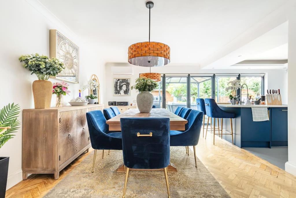 a dining room with a table and blue chairs at Gorgeous House in Sidcup in Streatham Hill