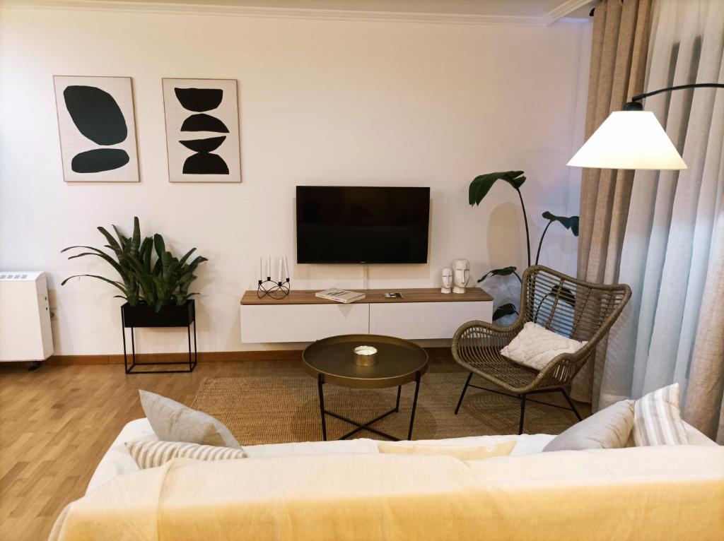 ein Wohnzimmer mit einem Sofa und einem TV in der Unterkunft As Conchas in Vilagarcia de Arousa