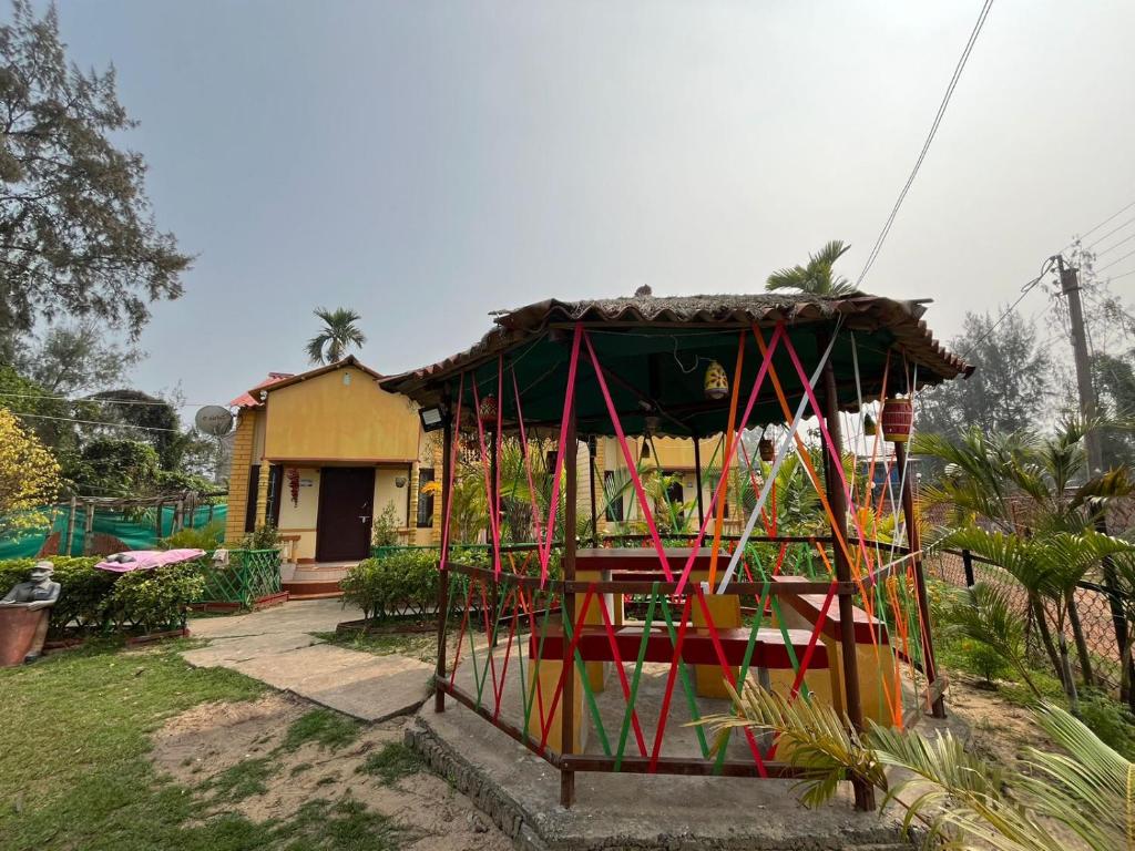 a small house with a colorful structure in the yard at Resort Green Earth in Tajpur