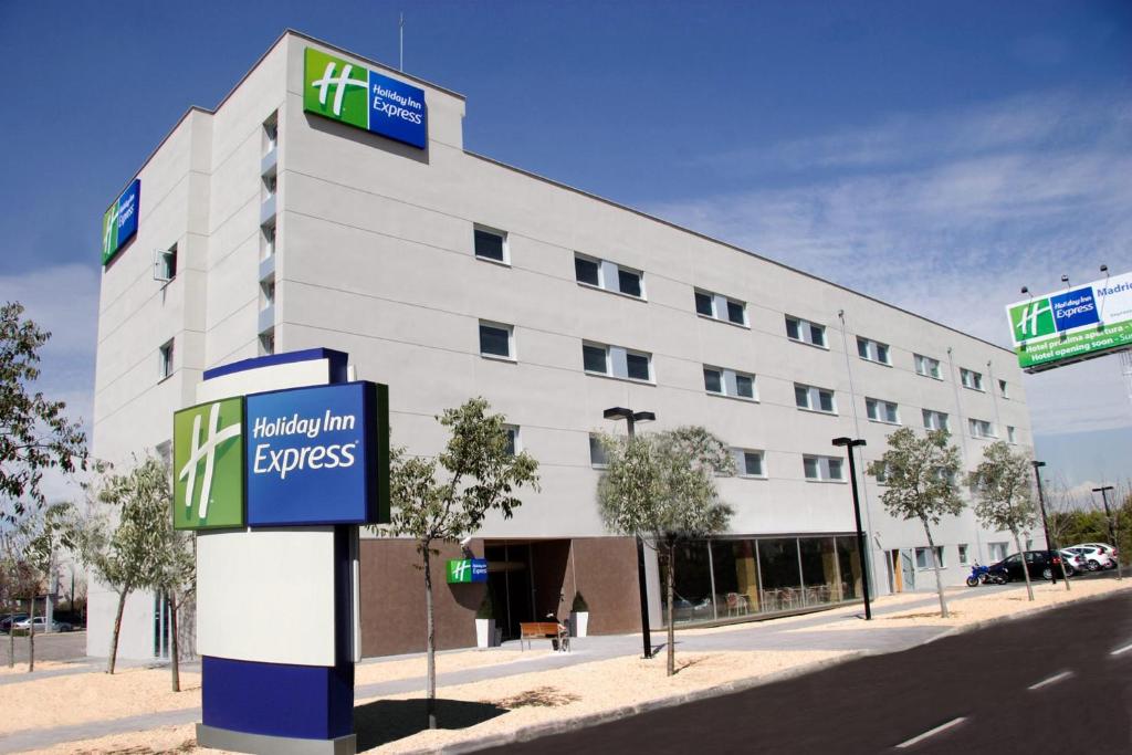 un gran edificio blanco con un cartel delante en Holiday Inn Express Madrid-Getafe, an IHG Hotel, en Getafe
