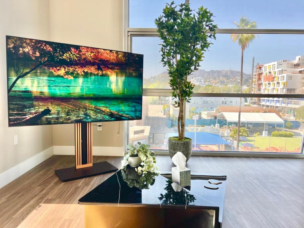 a living room with two large windows and a large monitor at Hollywood Sign View 2 Bed 2 Bath Premium Corner in Los Angeles