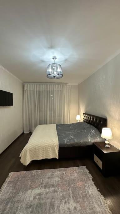 um quarto com uma cama grande e um lustre em Apartment for rent in Căușeni em Căuşeni
