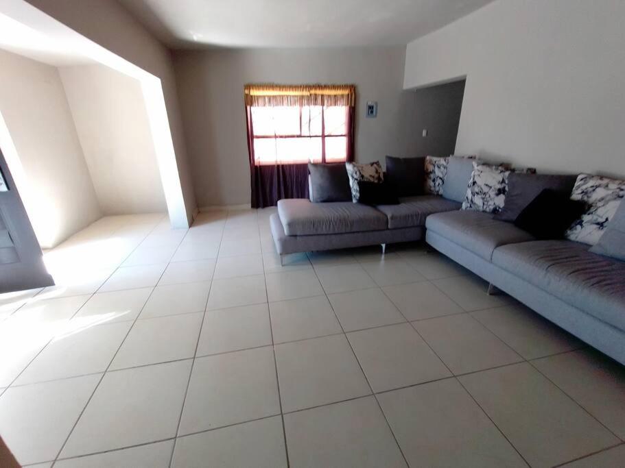 a large living room with couches and a window at Casa muy espaciosa y cómoda in Delicias