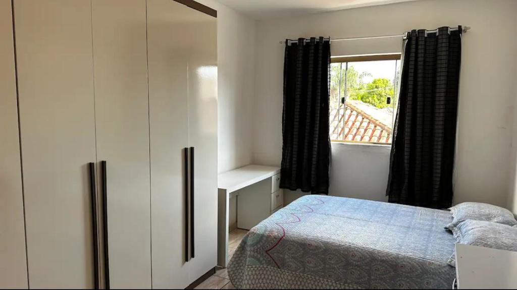 um quarto com uma cama e uma janela em Cantinho Feliz - Próximo ao Centro histórico em Tiradentes