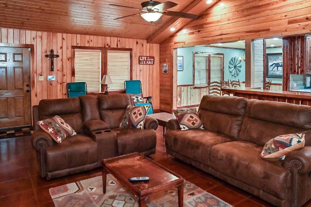 uma sala de estar com mobiliário de couro castanho num camarote em Cozy lakefront cabin with boat house and ramp on T em Alliance