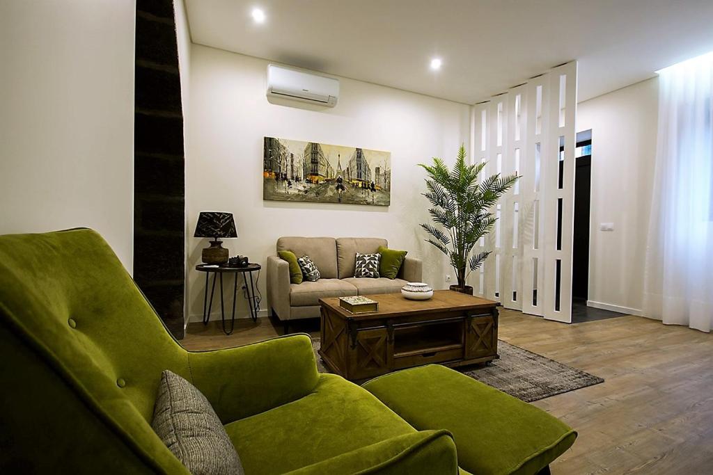 uma sala de estar com um sofá verde e uma mesa em INNature em Ponta Delgada