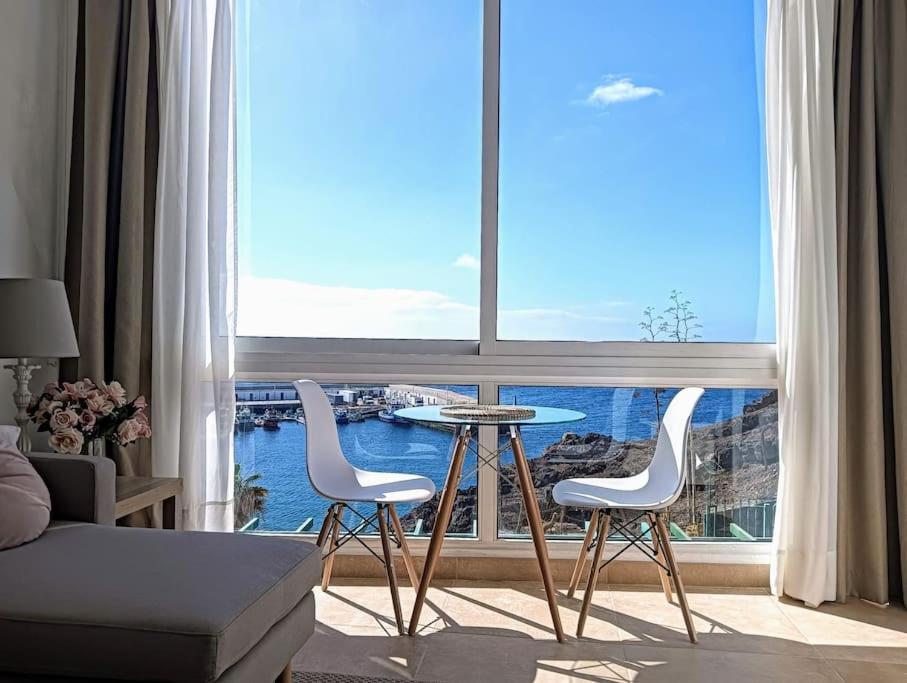 ein Wohnzimmer mit einem großen Fenster mit einem Tisch und Stühlen in der Unterkunft Casa Martín in Puerto del Carmen