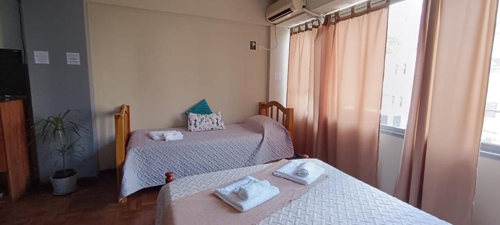 Habitación con 2 camas y toallas. en Av España Mdz en Mendoza