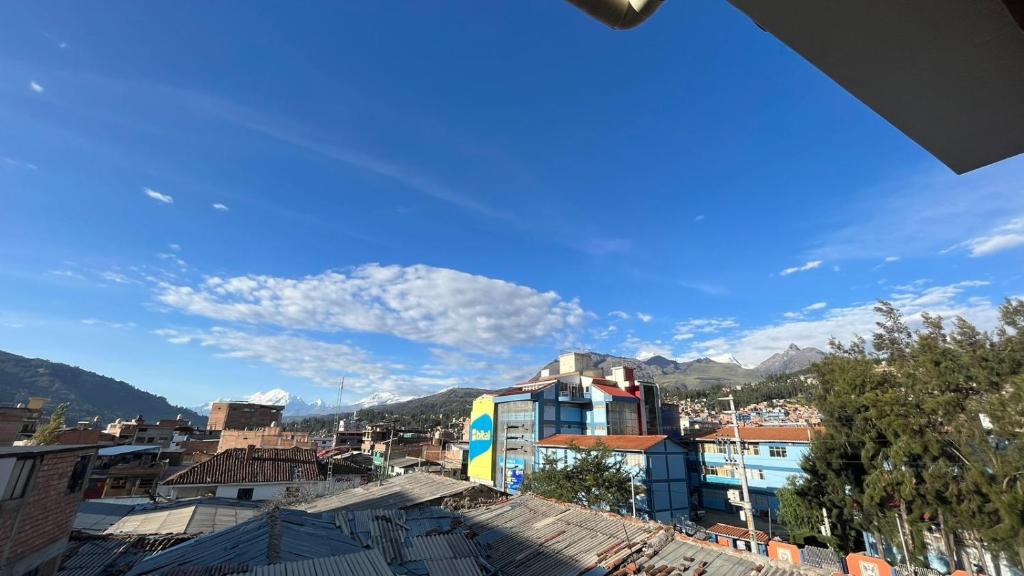 uitzicht op een stad met gebouwen en bergen bij Waylla Hostel in Huaraz