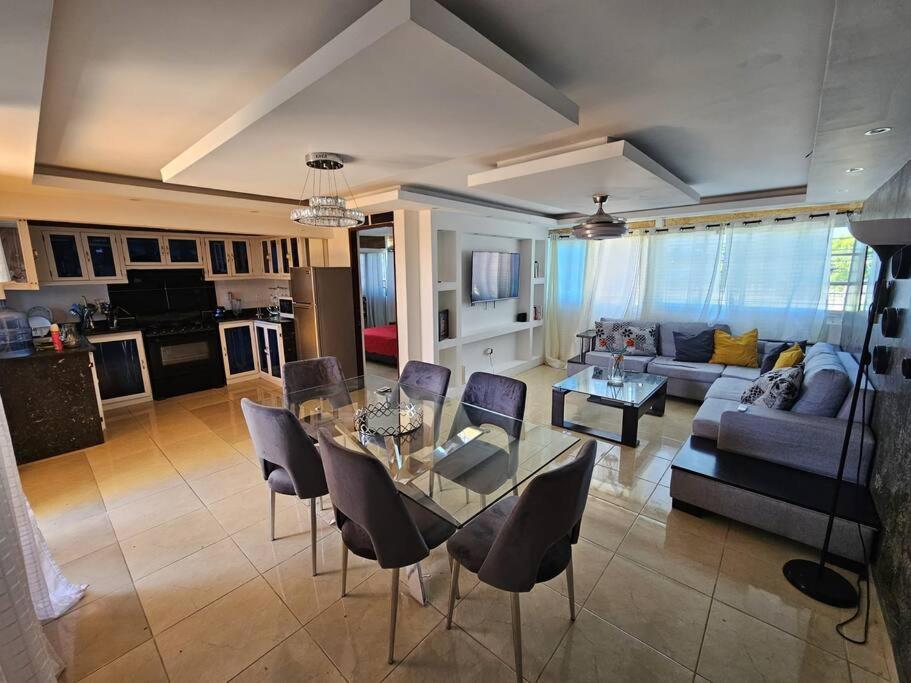 ein Wohnzimmer mit einem Tisch, Stühlen und einem Sofa in der Unterkunft Penthouse con Jacuzzy en Santo Domingo in Cancino