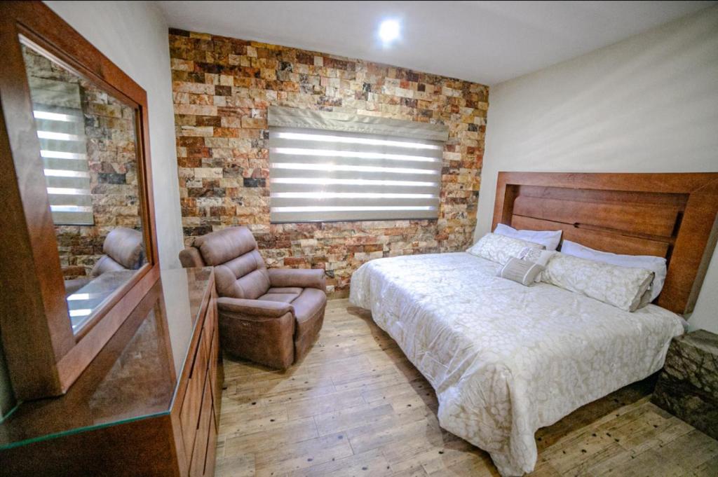 ein Schlafzimmer mit einem Bett, einem Stuhl und einem Fenster in der Unterkunft La Ocotera Hotel de montaña Cabañas Amenidades in San Marcos