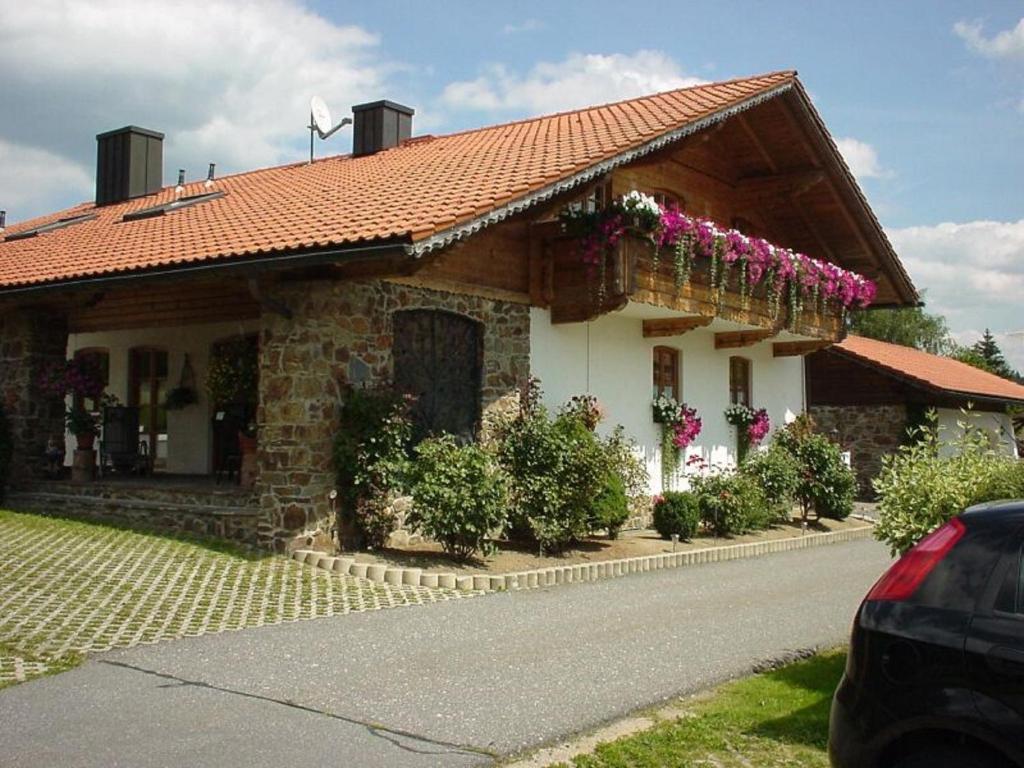 una casa con flores a un lado. en Ferienwohnung Späth, en Neuschönau