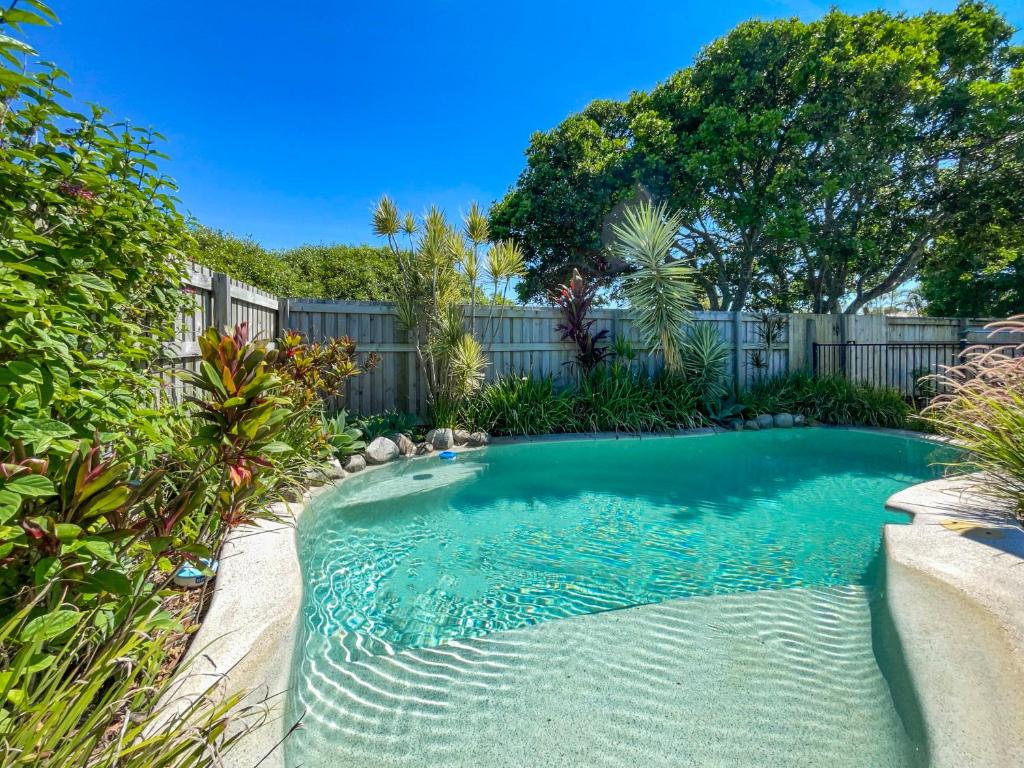 a swimming pool in a yard with a fence at Bokarina Family Pet Friendly Holiday Home in Kawana Waters