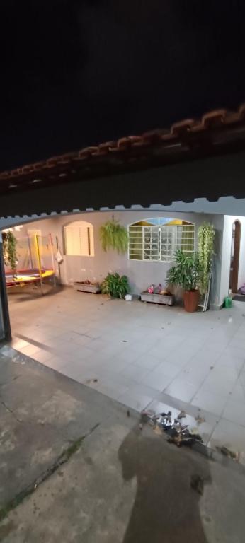 an empty patio with plants in a house at night at Casa completa in Marília