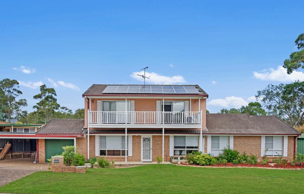 a house with solar panels on the roof at Discover Mount Annan - Spacious 6-BR House in Narellan