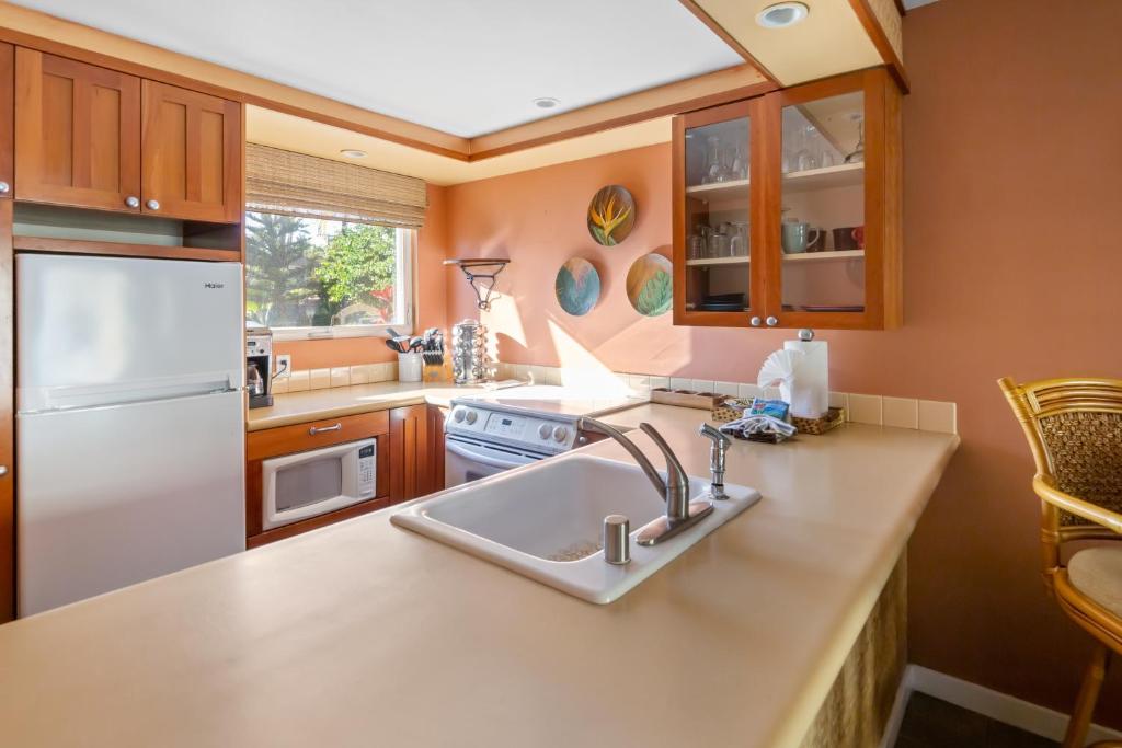 a kitchen with a sink and a refrigerator at Bamboo Suite located across from the beach, 1 Bedroom sleeps 4 in Kihei