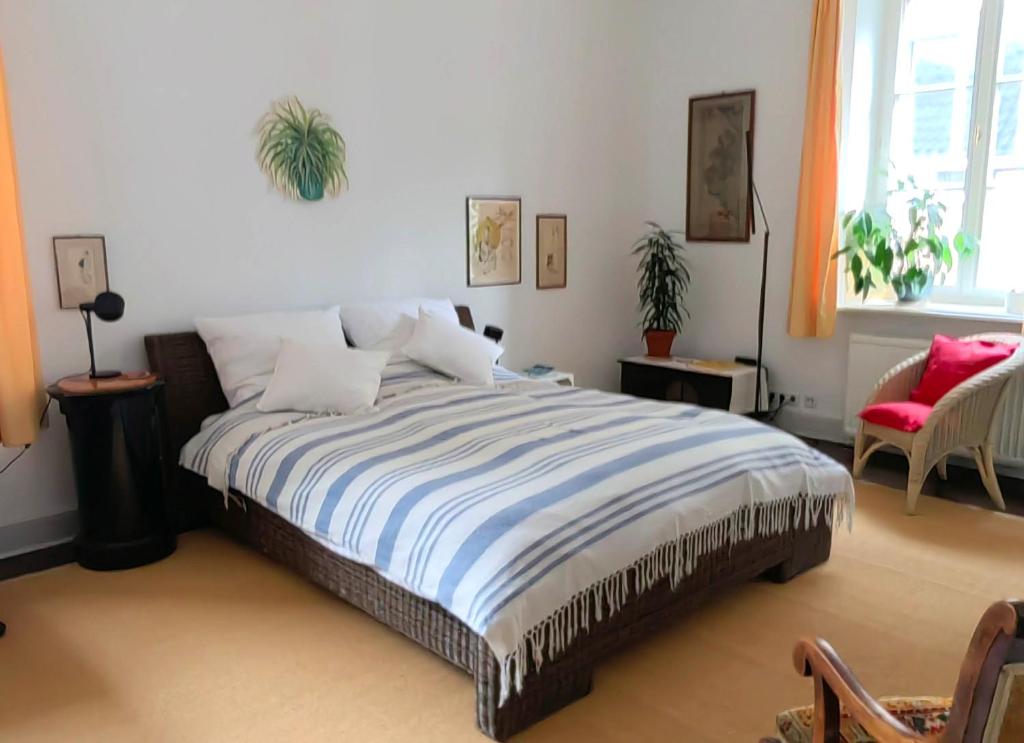 a bedroom with a bed and a red chair at Epic Location in Düsseldorf