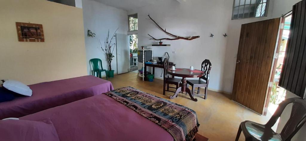 un soggiorno con letto viola e tavolo di Habitación Privada Doña Zoila a Flores