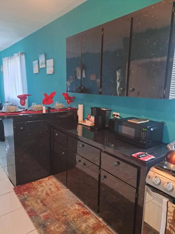 a kitchen with a black counter top with a microwave at Seashells in Nassau