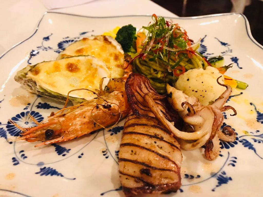 a plate of food with seafood and vegetables on it at Emperor Cruises Legacy Ha Long in Ha Long