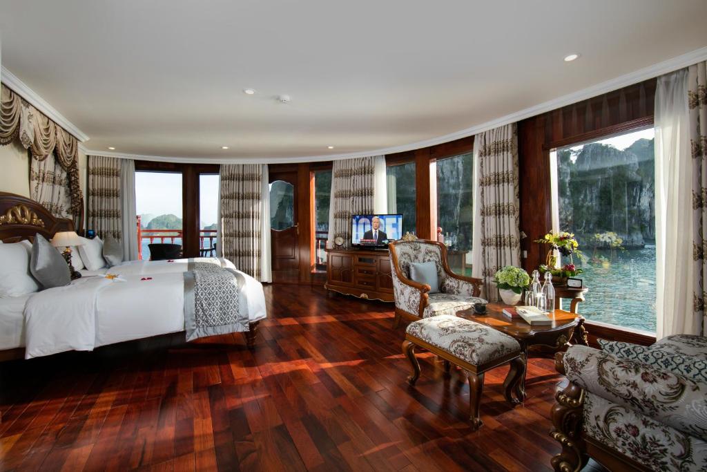 a bedroom with a bed and a tv and a couch at Emperor Cruises Legacy Ha Long in Ha Long