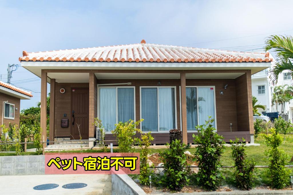 a small house with a sign in front of it at ヴィラ・アカバナー　B棟 in Miyako Island