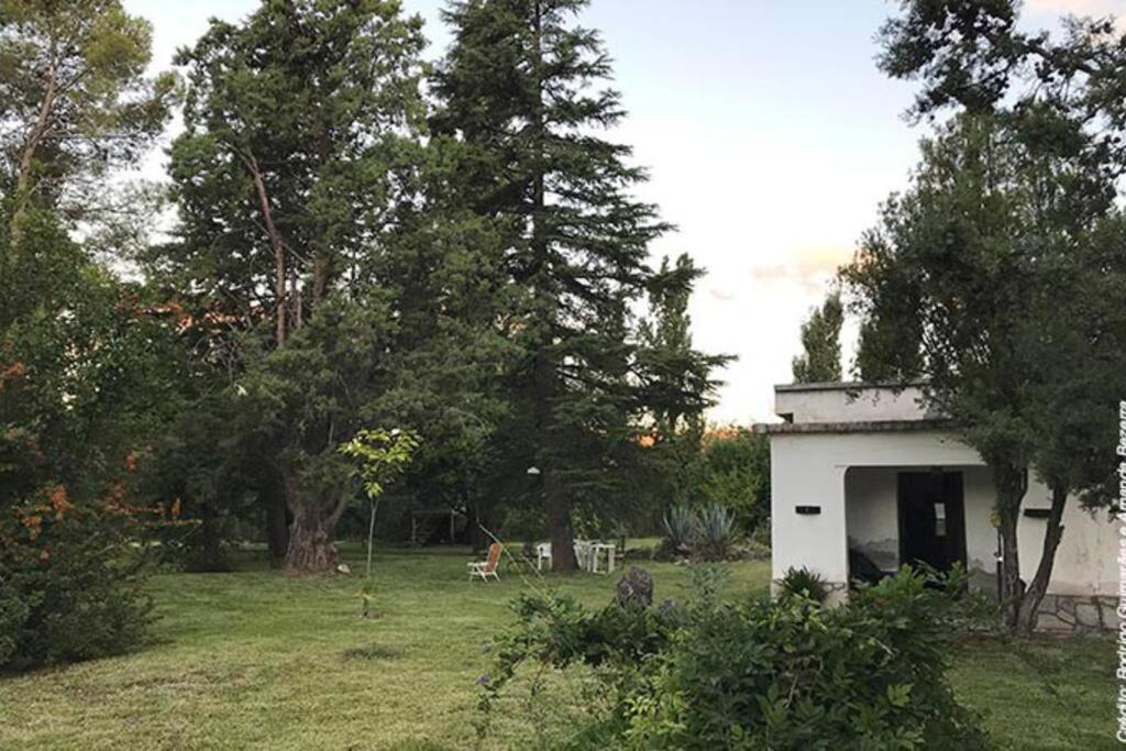 un piccolo edificio bianco in un campo alberato di Casa amplia en las sierras de San Luis a San Francisco del Monte de Oro