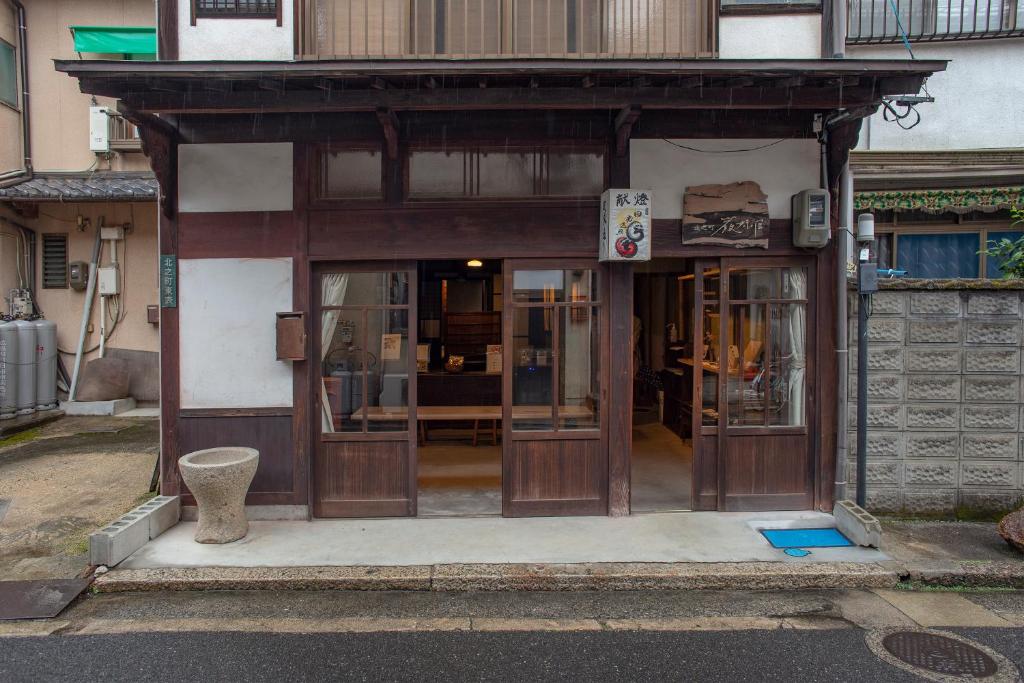 una entrada a un edificio con puertas de madera en Itsumoya, en Miyajima