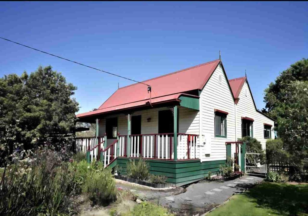 uma casa branca com um telhado vermelho em Relaxing & beautiful Miner's cottage near Wilson’s Prom em Foster