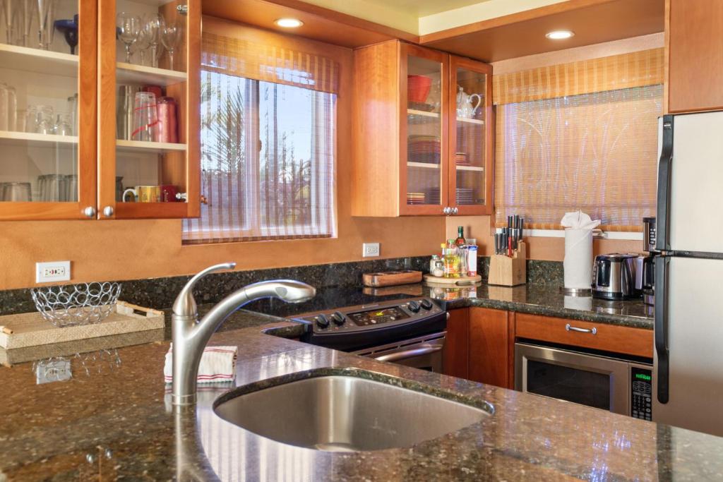 a kitchen with a sink and a refrigerator at Orchid Suite in South Maui, across from the beach, 1 bedroom sleeps 4 in Kihei